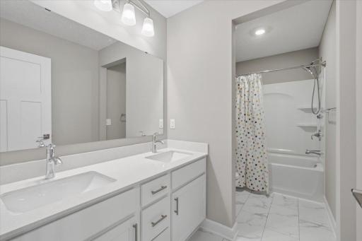 Upper-level full bathroom with a double sink vanity.
