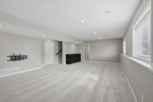 Spacious lower-level family room offering a comfortable space to relax, entertain or gather with family and friends.