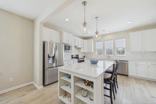 Beautiful kitchen with a spacious island, including solid surface counters with built ins with added storage. Stainless steel appliances, custom cabinets, kitchen window overlooking large back yard & pond.