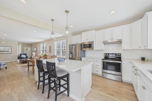 Beautiful kitchen with a spacious island, including solid surface counters with built ins with added storage. Stainless steel appliances, custom cabinets, upgraded window treatments.