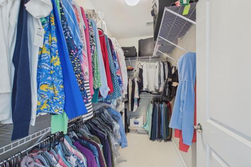 Large primary walk in closet (8.11x5.3) with closet organizers & hanging rack.