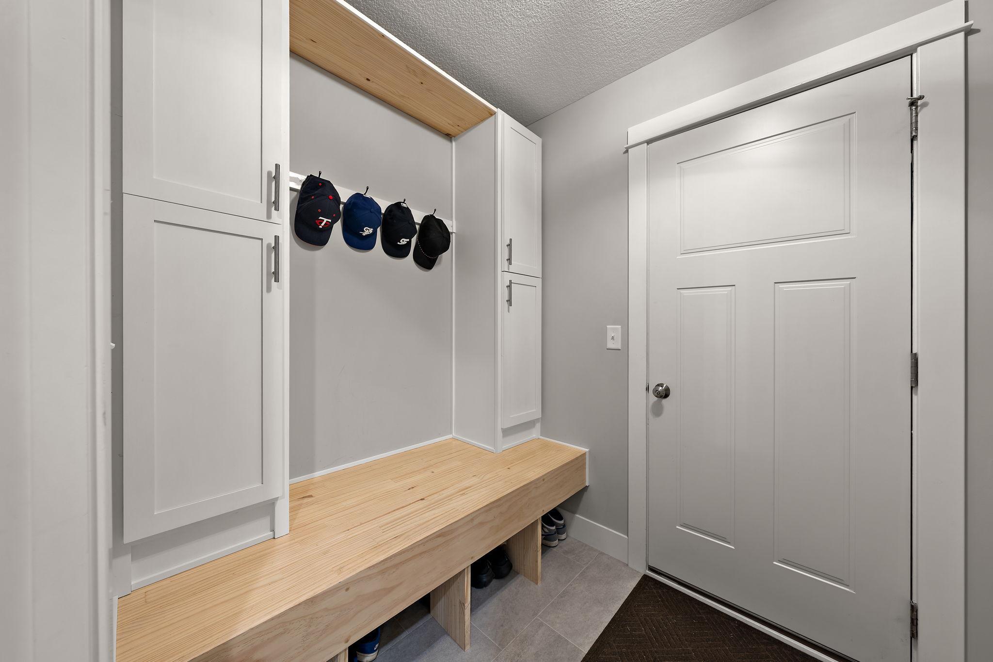 The mudroom with adjoining door to the garage. The cabinets and bench were installed in 2025.