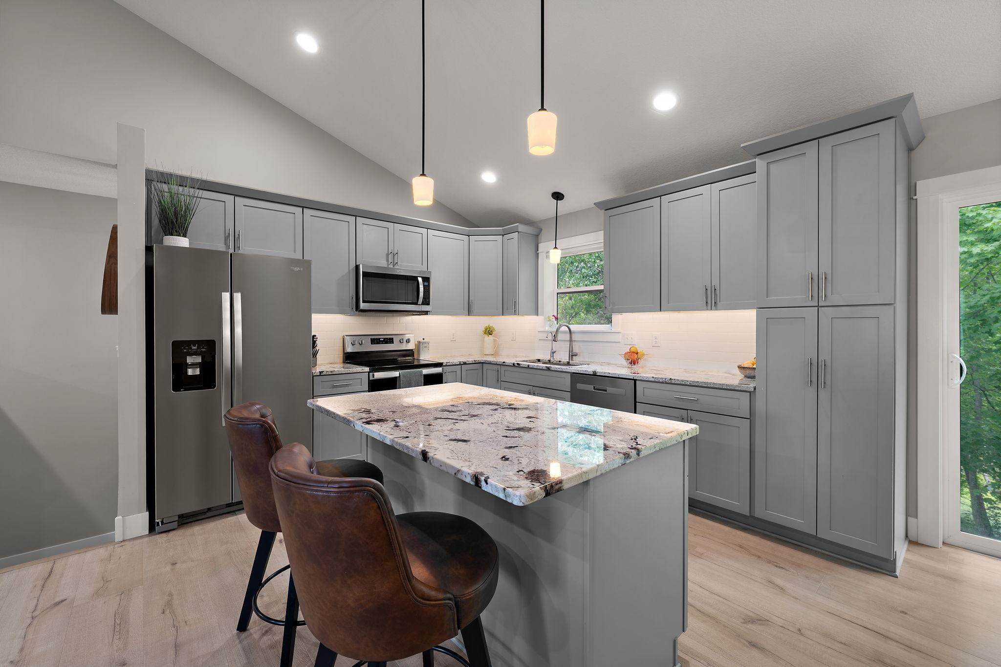 The kitchen has granite countertops, stainless steel appliances, tiled backsplash and soft close cabinetry with ample storage space.