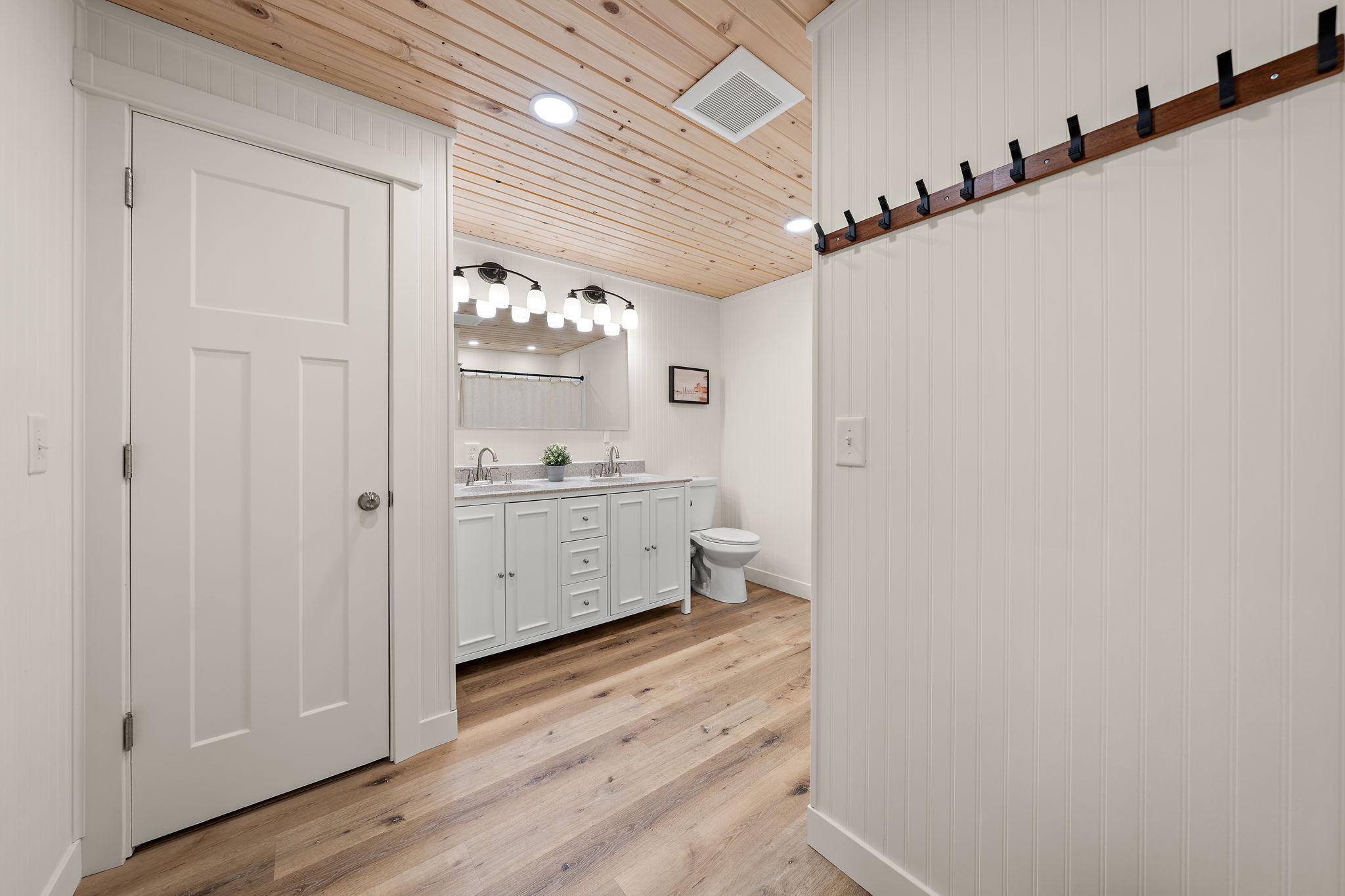 The lower level full bathroom features double sinks and a linen closet to the left.