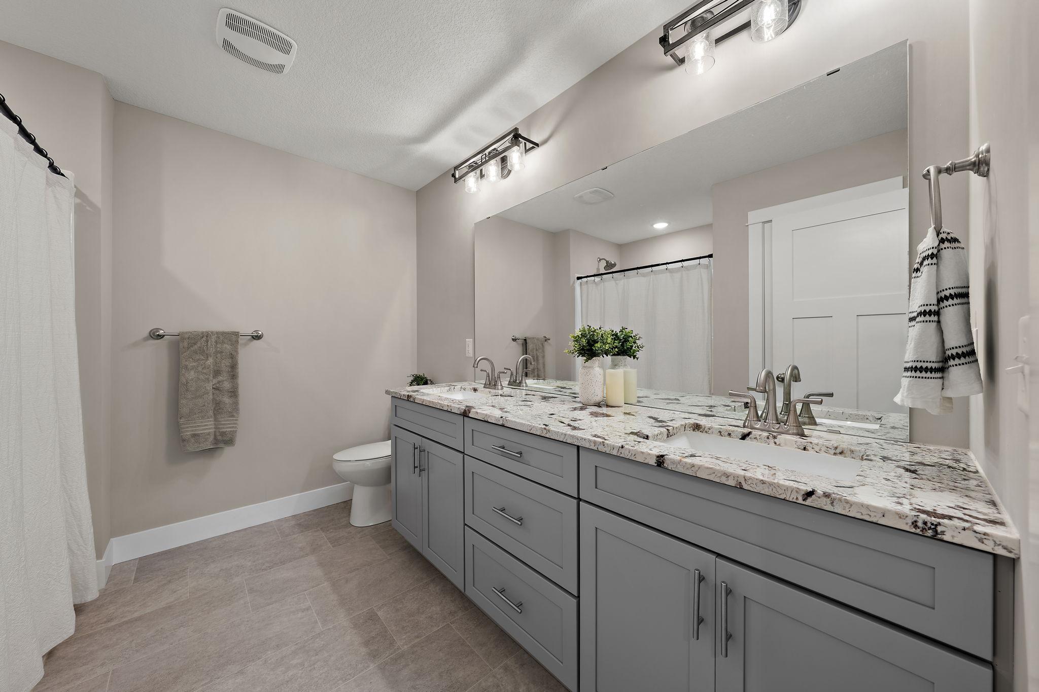The primary ensuite bathroom features double sinks and spacious cabinetry.