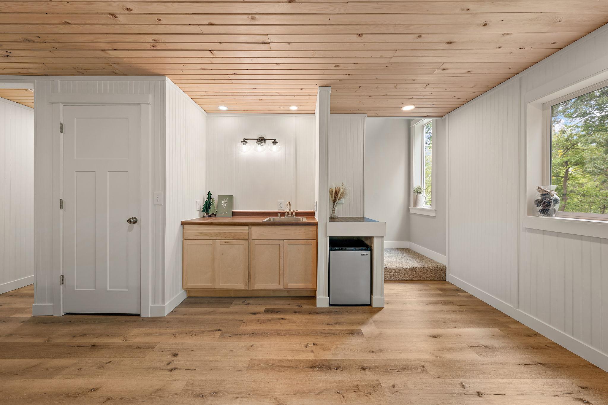 The basement level has a wetbar and a storage closet with hallway to the utility room and fourth bedroom on the far left.