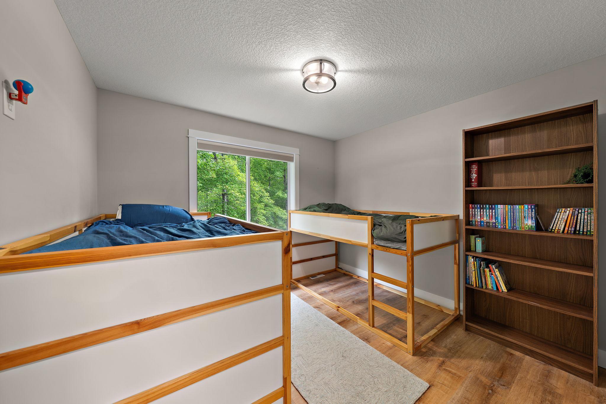 The third bedroom on the main floor features new LVP flooring and a window view of the back yard.