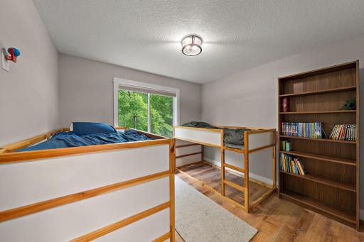 The third bedroom on the main floor features new LVP flooring and a window view of the back yard.