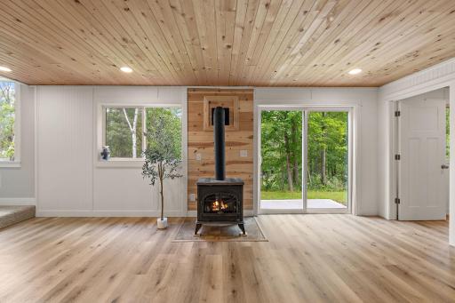 The freestanding gas stove is a cozy addition to the lower level to chase away the chill of cool nights. The walkout basement leads out to the backyard. The fifth bedroom is through the open door on the right.