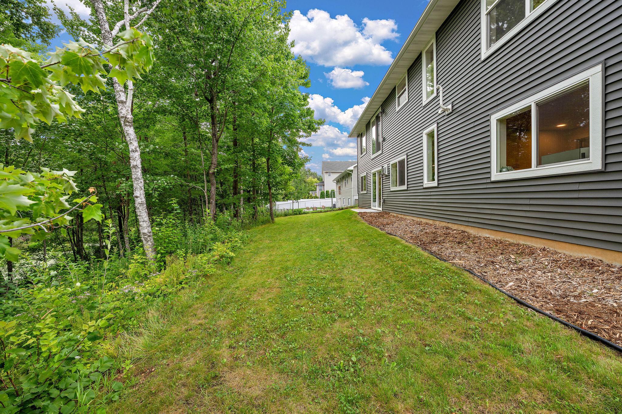 The home had landscaping completed in 2025 with the back yard seeded at that time as well. The back of the home features heavy tree coverage and a pond to the left of this photo.