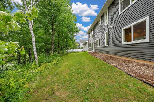 The home had landscaping completed in 2025 with the back yard seeded at that time as well. The back of the home features heavy tree coverage and a pond to the left of this photo.