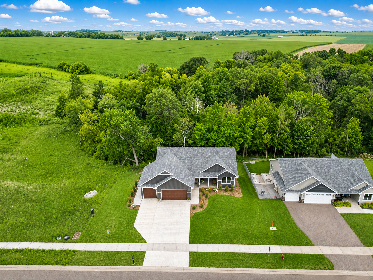 An aerial view of the property showing the neighborhood and rolling farmland on the horizon.