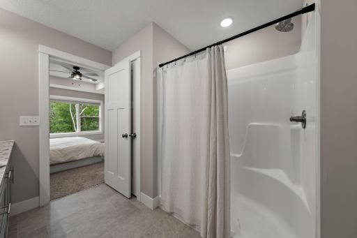 A view from the bathroom with open door to the primary bedroom beyond. The primary ensuite bathroom has a walk-in shower.