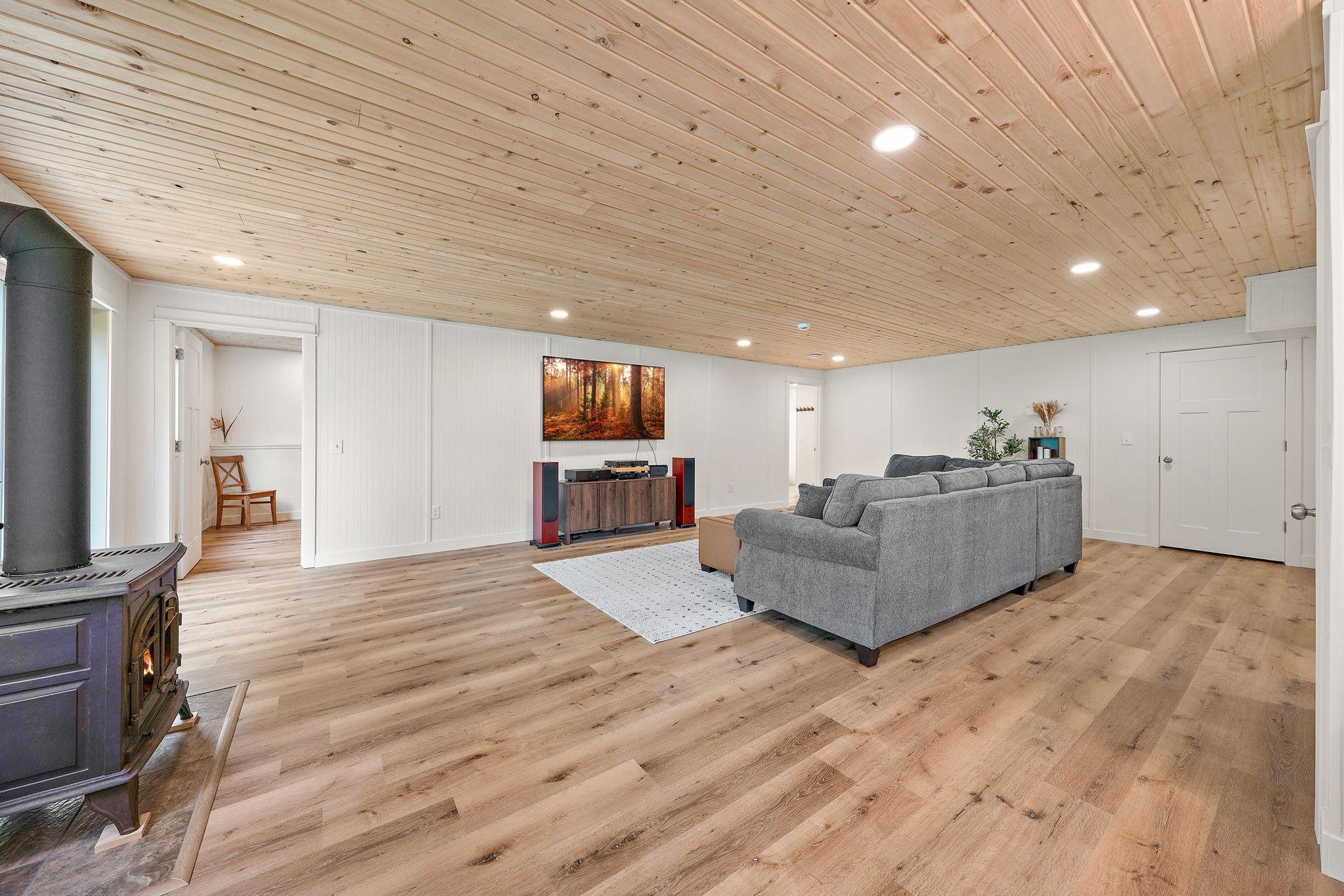 The lower level basement is fully finished with hardwood floors, tongue and grove ceiling and a gas stove.
