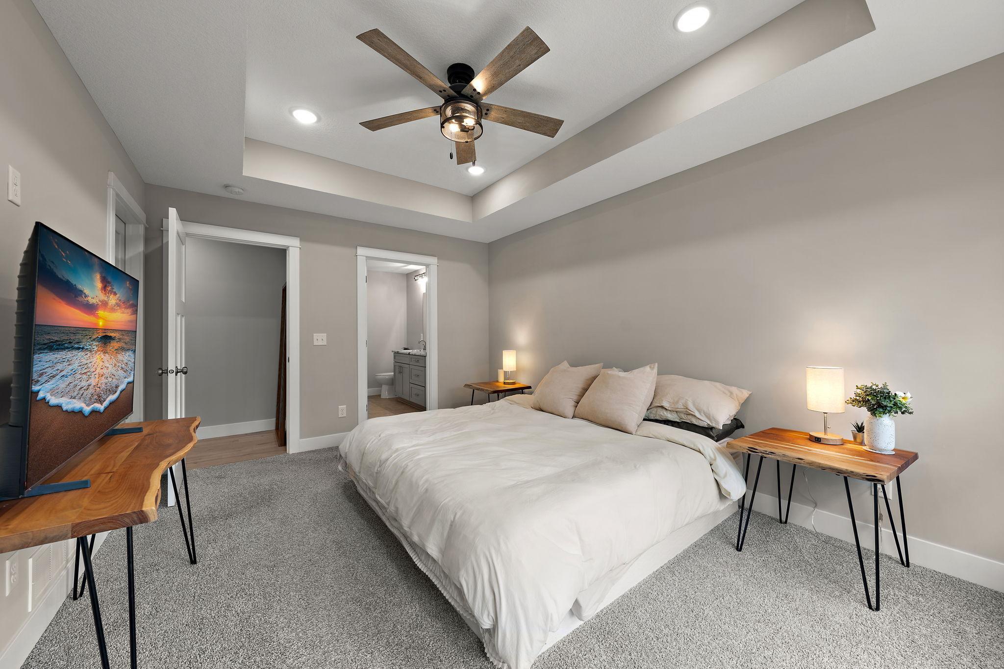 The primary bedroom with door to the main floor hallway on the left and door to the ensuite bathroom on the right.
