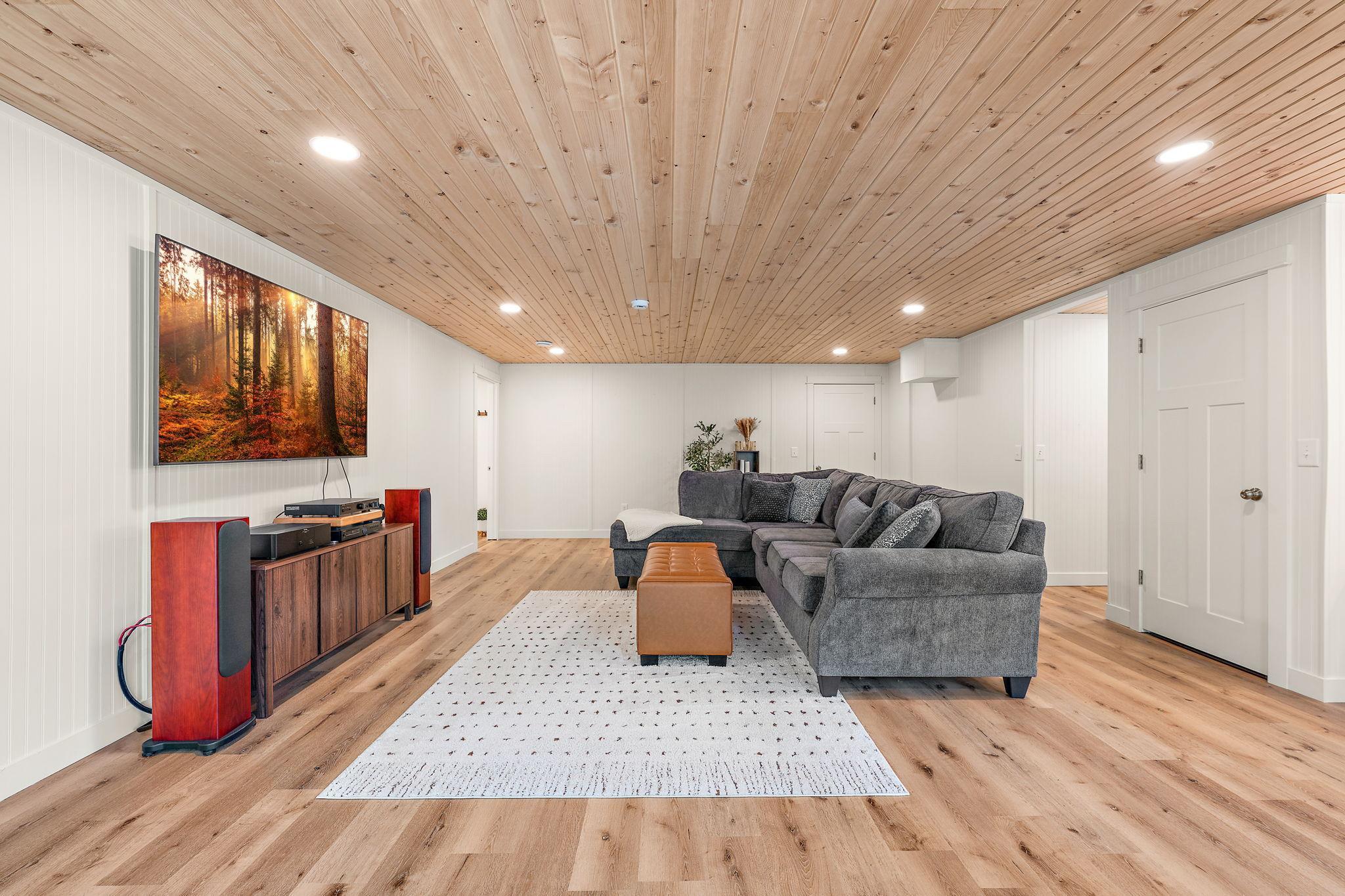 The lower level family room is perfect for relaxing or entertaining. The lower level full bathroom is on the left and a small closet is directly across the room with the hallway to the storage/utility room and fourth bedroom on the right.