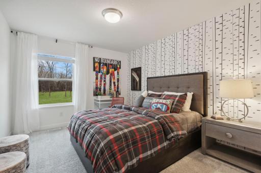 (Photo of a decorated model, actual homes finishes will vary) One of two generously sized upper level secondary bedrooms with spacious closets.