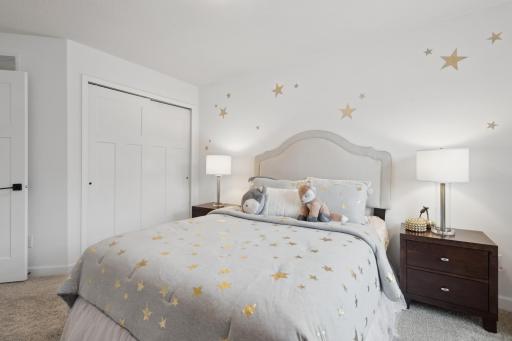 (Photo of a decorated model, actual homes finishes will vary) The second generously sized upper level secondary bedroom with a spacious closet.