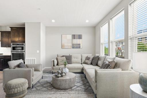 5140 Hampton St NE - the spacious living room is open to the kitchen and dining area beyond. Access to the balcony is to the right.
