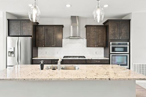 5140 Hampton St NE - this gourmet kitchen is a cook's dream, with gas cooktop, professional vent hood, granite countertops, double wall oven/microwave, and large island with bar.