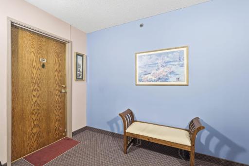 Brightly lit halls lead to this second floor corner unit.