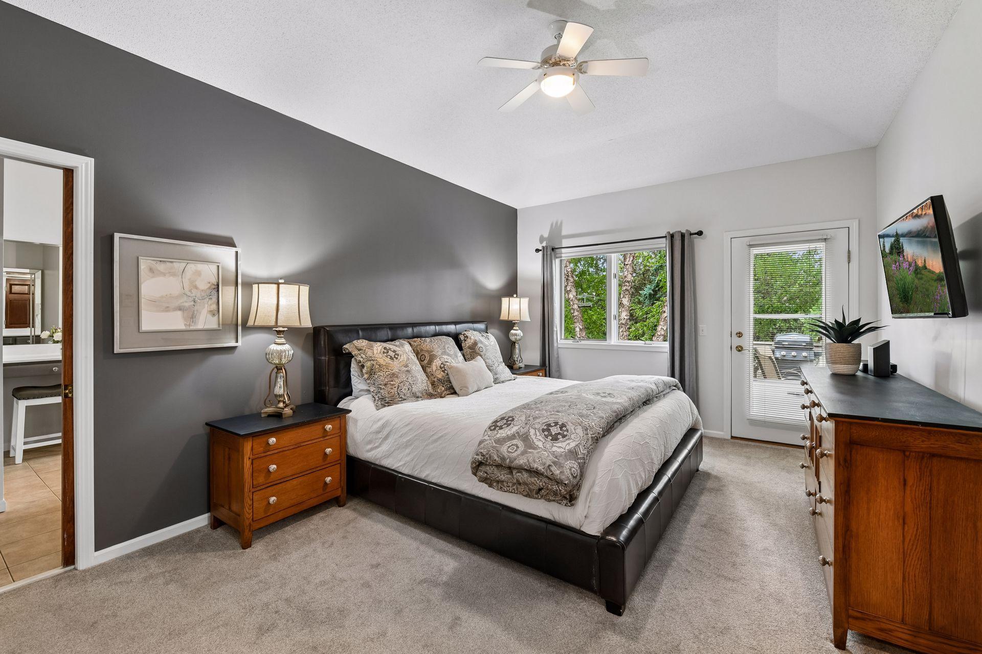 The main-level primary suite is a private retreat with a vaulted ceiling, spacious walk-in closet and full bath featuring dual sinks, a separate shower and jetted tub.