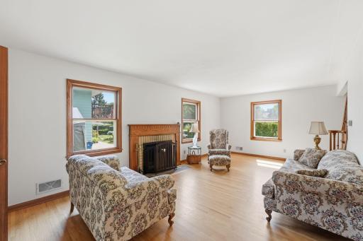 Inviting living room with beautiful original hardwood floors and wood fireplace