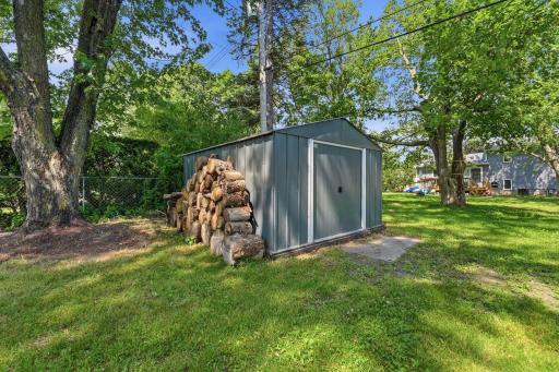 Metal shed with wood already cut and stacked for nights gathered around a fire.