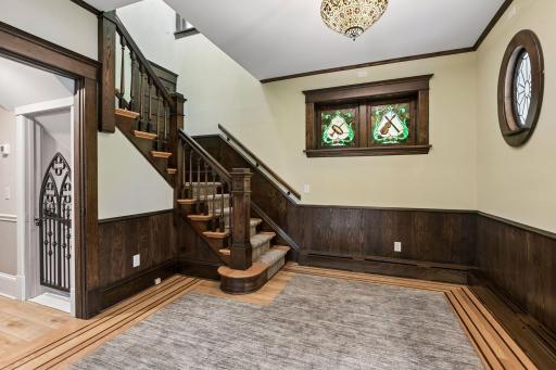 Entry hall with music theme stained-glass windows and a leaded glass oval window