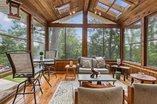 Three-season retreat with wood accents, skylights, and serene wooded views.