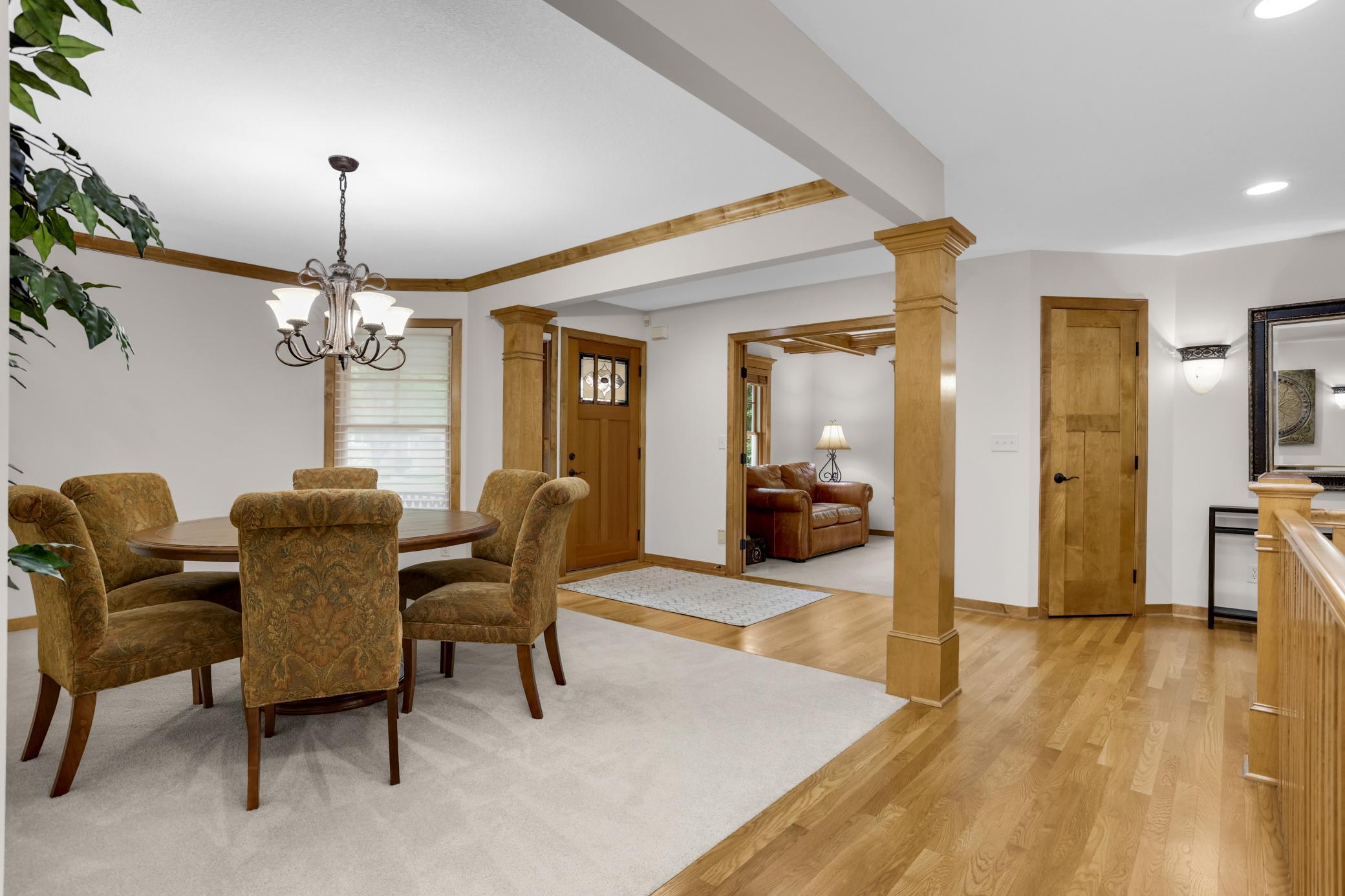 Beautiful view of the dining room, den, and entryway, highlighted by rich wood finishes that create a warm and inviting feel.