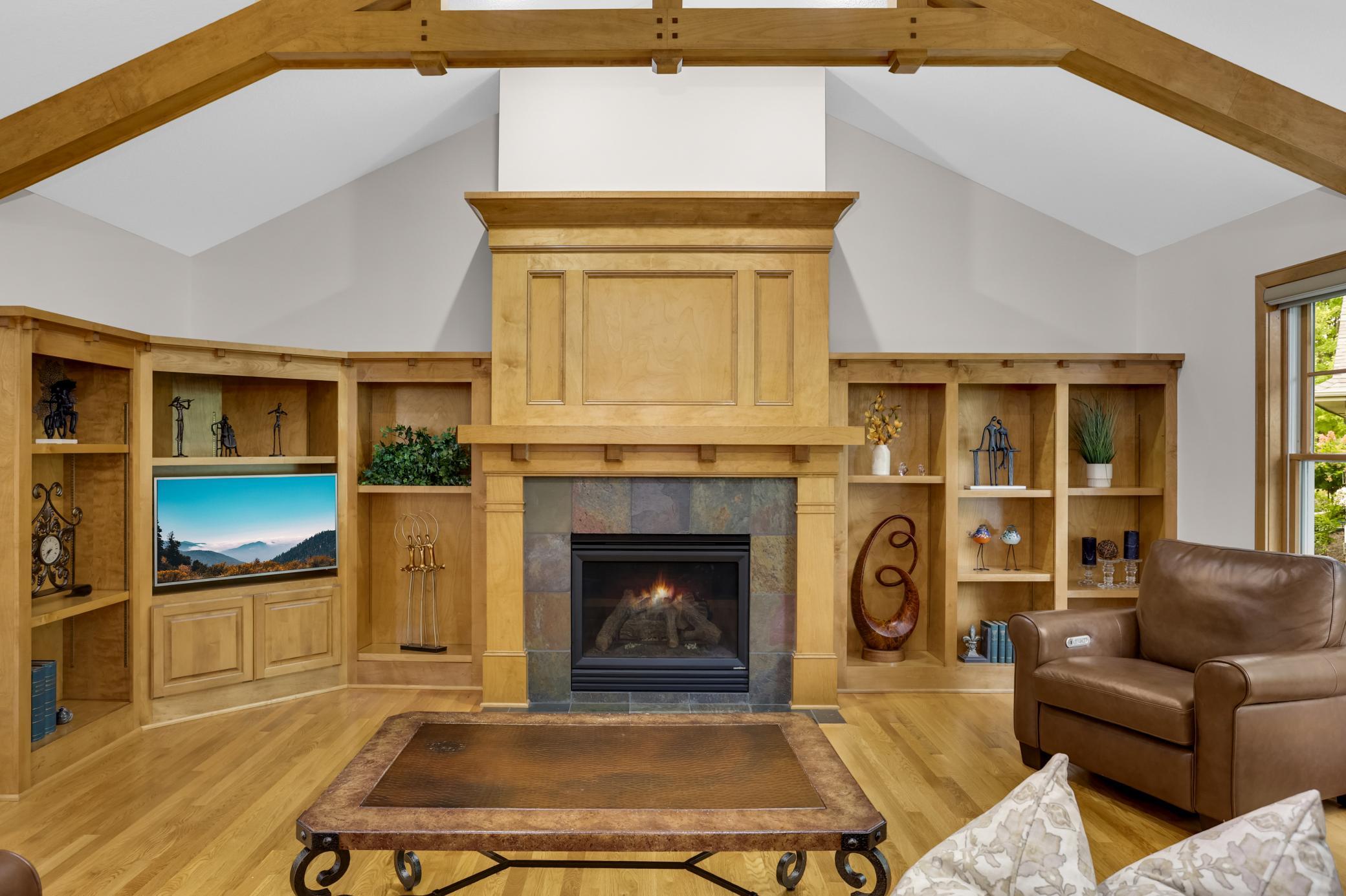 Custom maple built-ins surround the cozy fireplace, creating a warm and inviting focal point in the room.