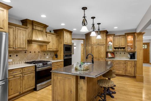 Neutral tile backsplash, convenient coffee bar, dual ovens, and abundant knotty alder cabinetry that adds warmth and character.