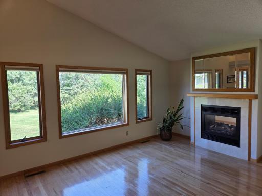 Living room with beautiful wooded views and gorgeous wood flooring.