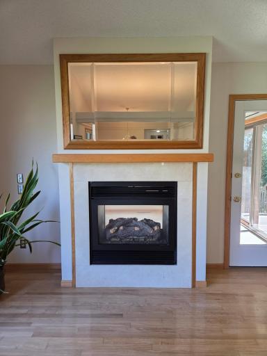Warm and cozy see thru Fireplace looking into the bright and sunny Sun Room.