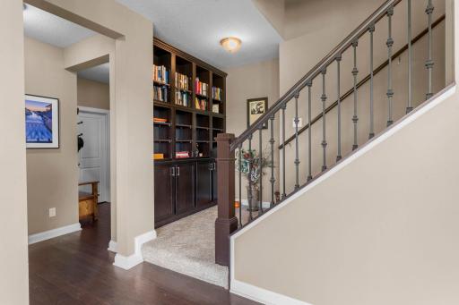 Wide, welcoming staircase leading to the second level with bookshelf