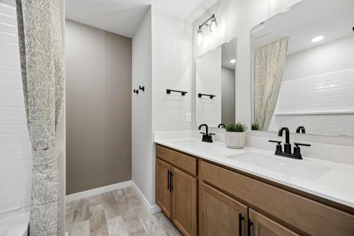 A spacious main hall bath features two sinks, as shown in the Hadley model.