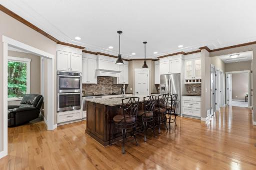Gourmet kitchen with granite countertops, custom cabinetry and convenient walk-in pantry
