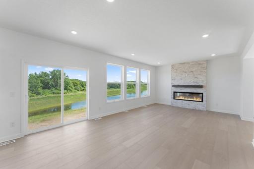 (Photo of a similar home, actual finishes may vary) A wall of large windows in the Great Room offer a sunlit view of the neighborhood and brighten daytime gatherings. It’s an ideal space for relaxing and enjoying the company of loved ones.