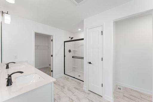 (Photo of a similar home, actual finishes may vary) The walk-in closet is easily accessible through the bathroom