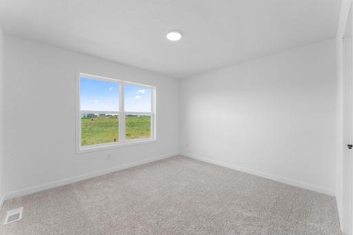 (Photo of a similar home, actual finishes may vary) Located on the first floor, this bedroom can accommodate overnight guests or visiting family members. It is adjacent to a bathroom for easy convenience.