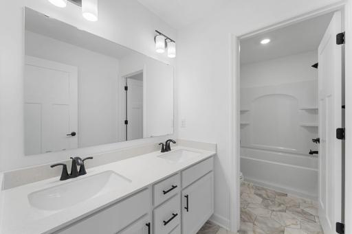 (Photo of a similar home, actual finishes may vary) A full bathroom on the second floor comes well-equipped with an optimal dual-sink vanity, which can close off from the combination shower and tub for an added layer of privacy.