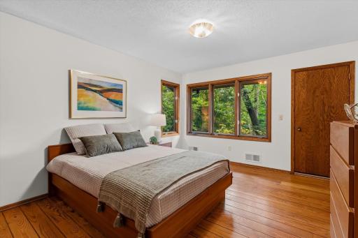 The spacious primary bedroom offers more stunning views of the backyard.