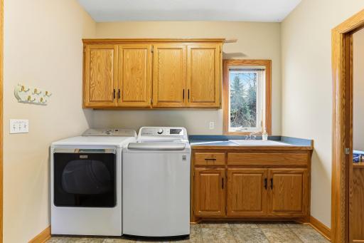 Stylish main-floor laundry elevated by custom cabinetry and a sleek sink.
