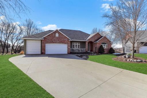 Three-car garage with generous concrete drive and a tall third-stall door for oversized vehicles.