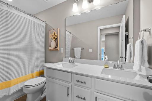 Upper level full bath with a double vanity and quartz countertops