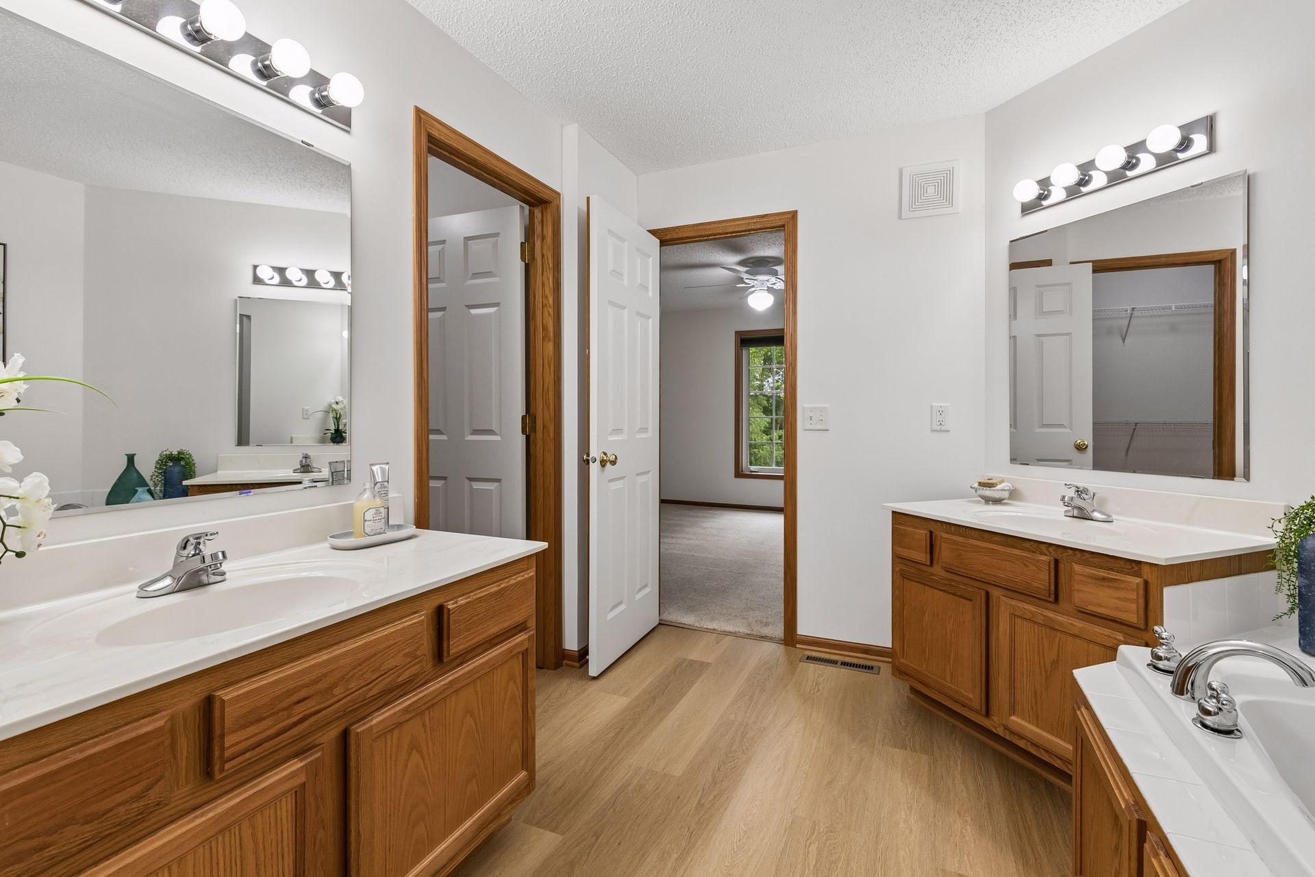 Primary Bath with dual vanities, walk in closet, tub and separate shower