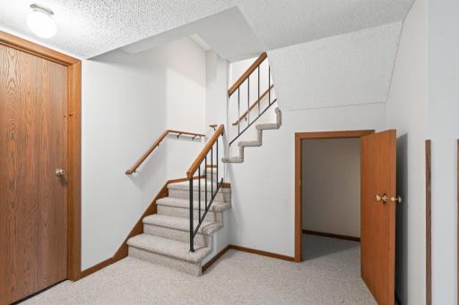 Storage at the foot of the basement stairs, mechanical/storage room to left