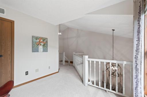 Upstairs, a small hallway leads to a shared bathroom and the loft
