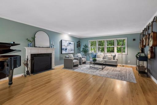 Large formal living room with beautiful hardwood floors and w.b. fireplace. This view is looking towards the back of the home